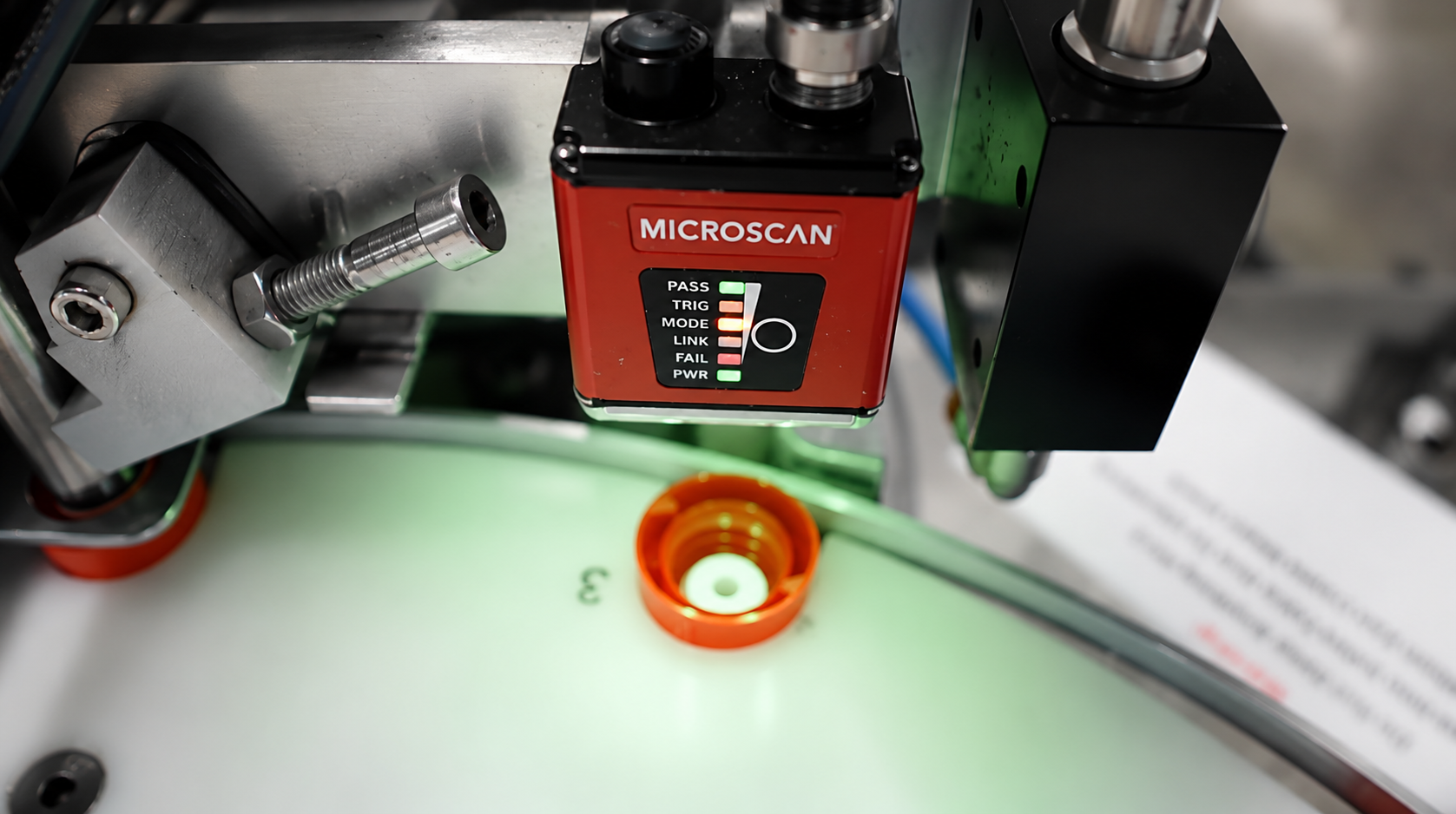Inline code reader verifying caps on a rotary assembly table
