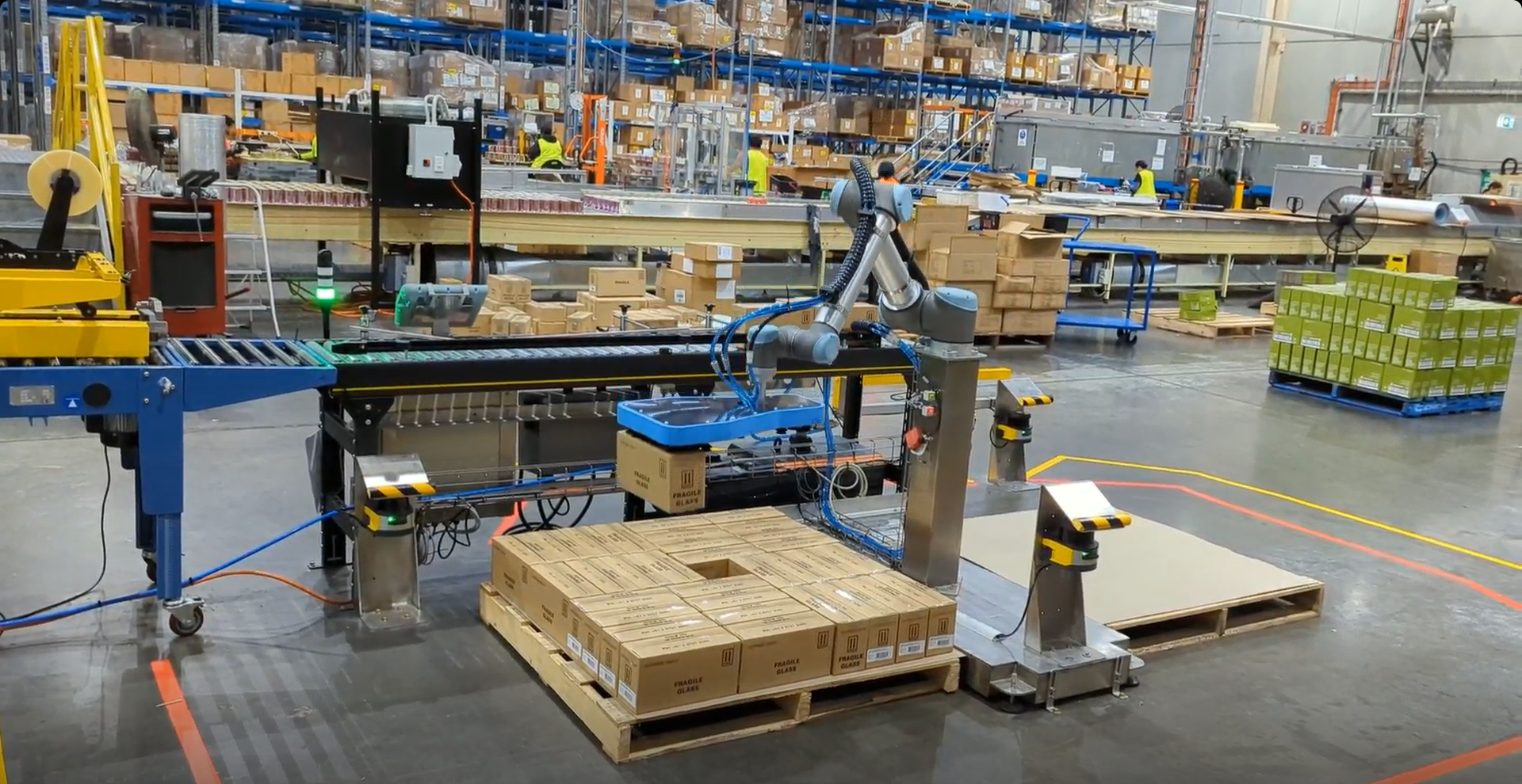 UR cobot palletising boxes in warehouse